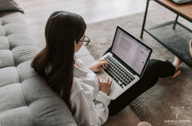 Remote work from home with woman using laptop on sofa